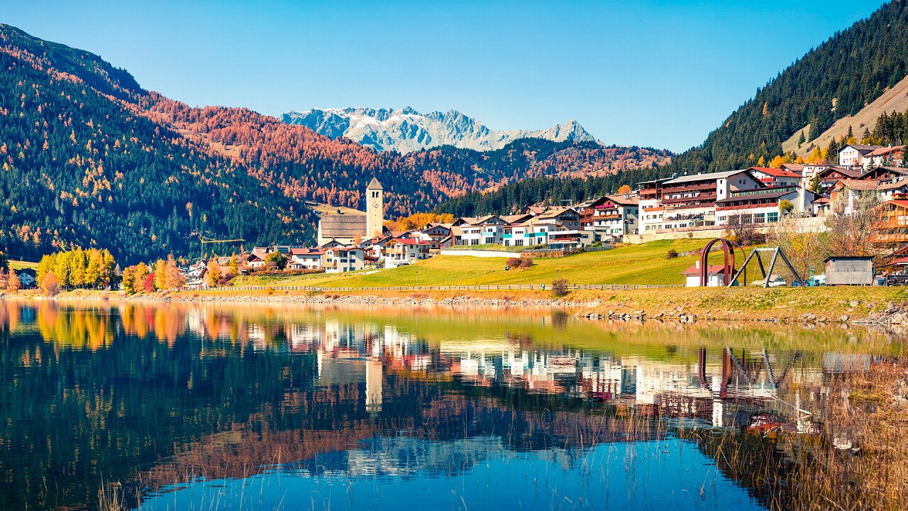 Resia village reflected in the lake in autumn
