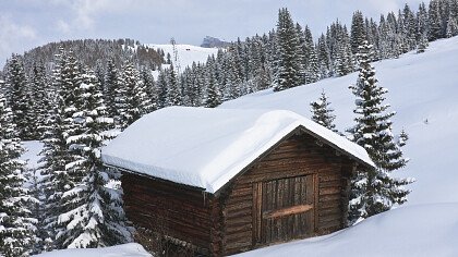 Holzhaus umgeben von Schnee in Wolkenstein in Gröden