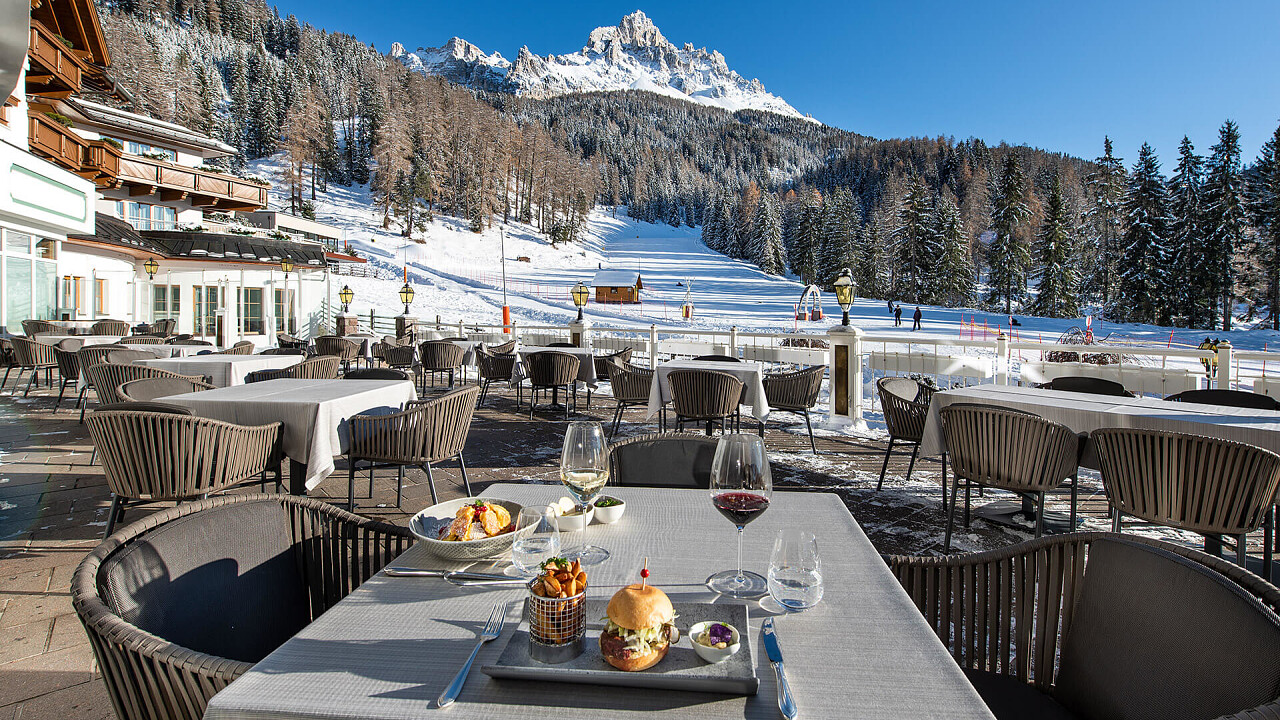 Tavolo con bicchieri vino e cibo in inverno vicino pista sci Hotel Sonnalp