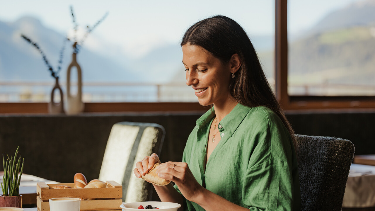Ragazza seduta al tavolo che fa colazione Hotel B&B Feldmessner