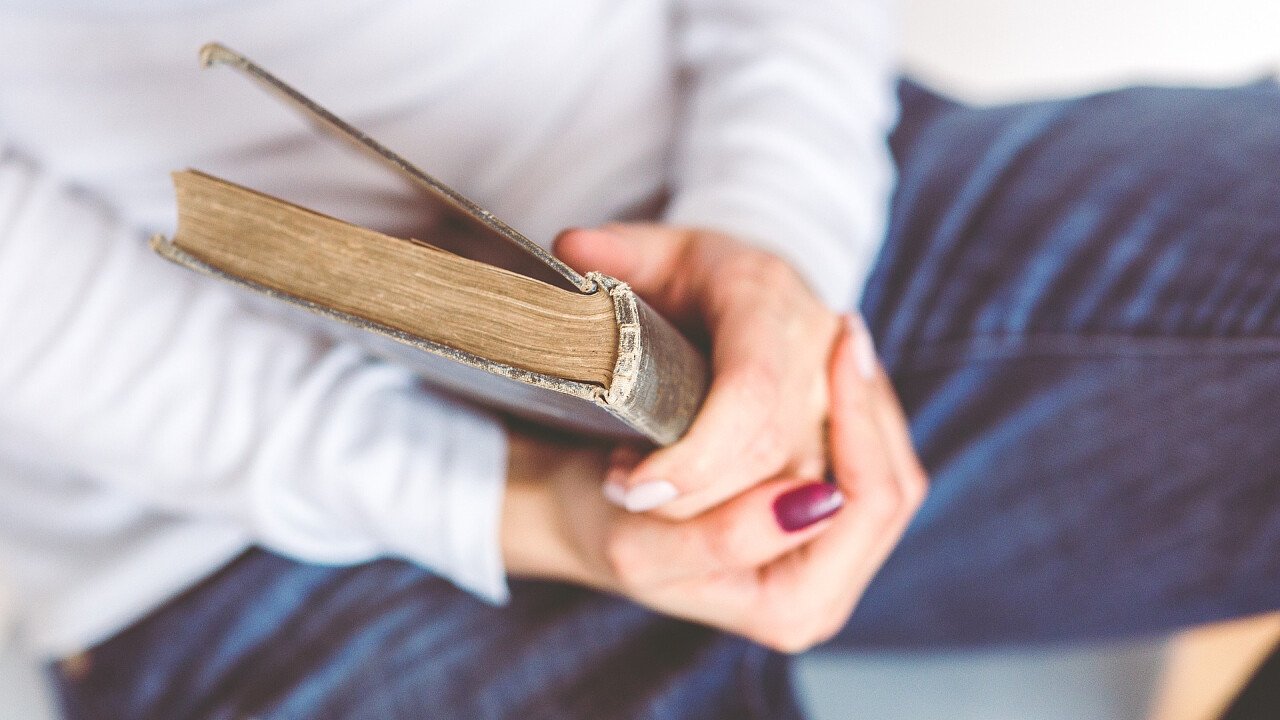 persona_tiene_in_mano_libro_pixabay_stocksnap