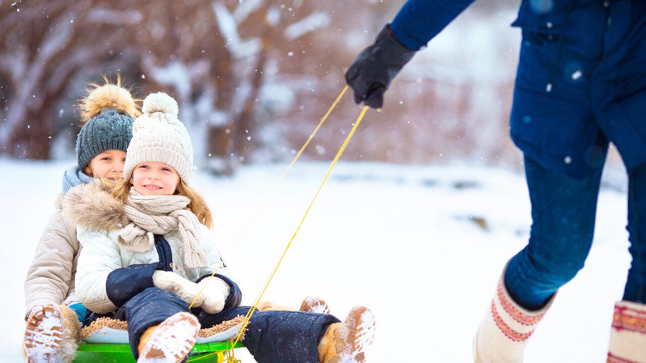 mamma_traina_bambini_sullo_slittino_shutterstock