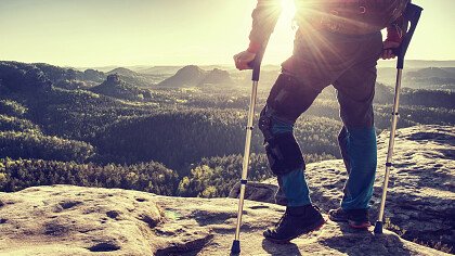 Man with crutches in the mountains in winter